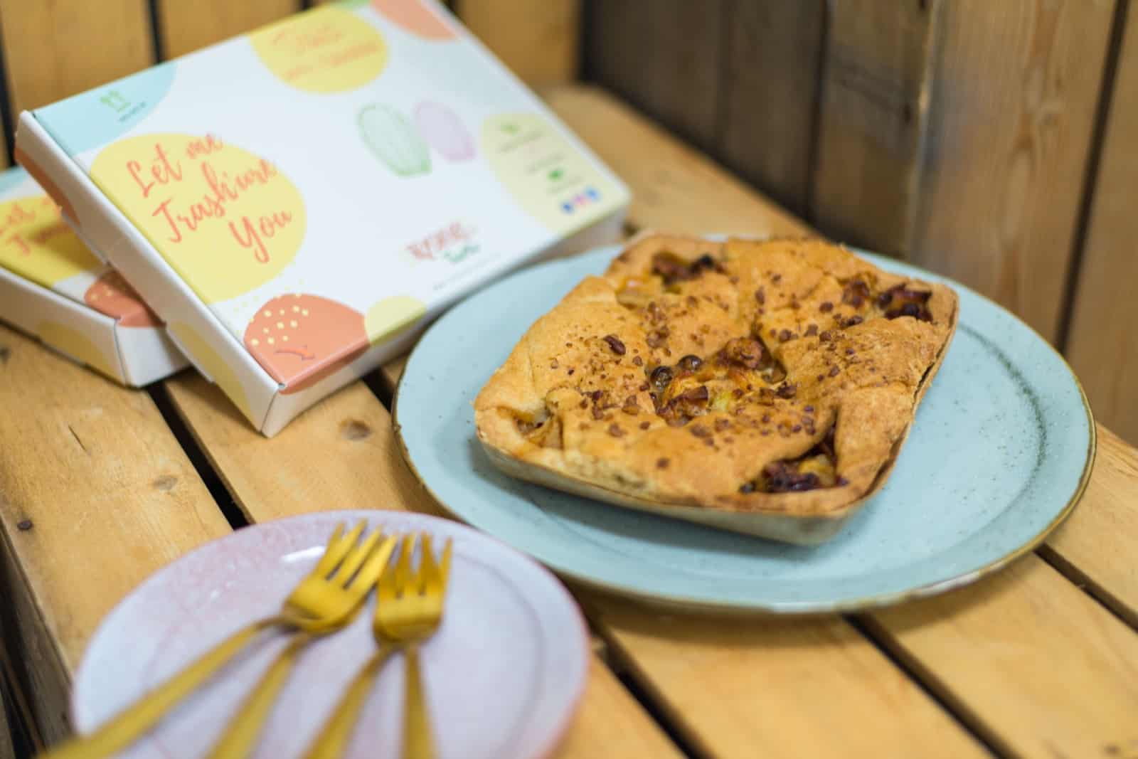 Een brievenbustaart op een bordje. Daarnaast een kaartbordje met vorkjes en de kartonnen verpakking.