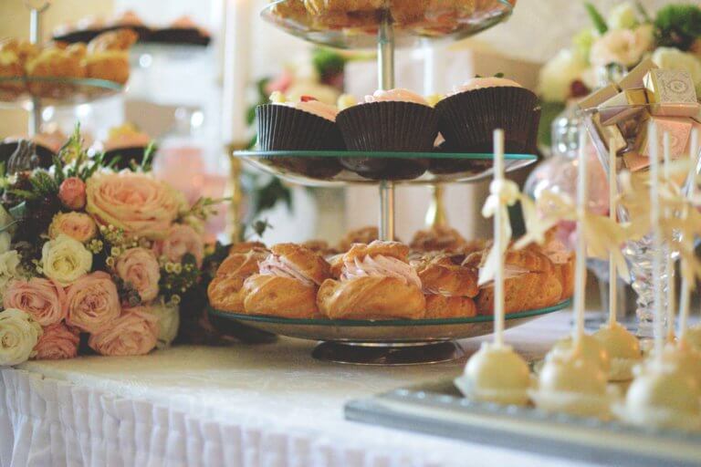 Een mooi aangeklede tafel met cupcakes, soezen en bloemen
