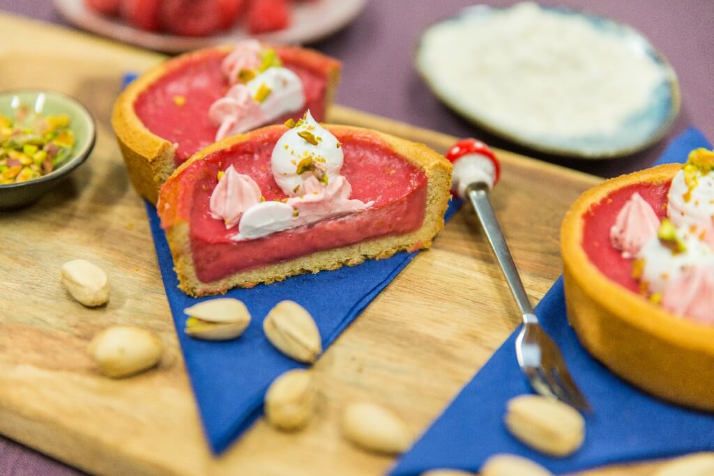 Kleine verjaardagstaartjes met rode creme en pistache.