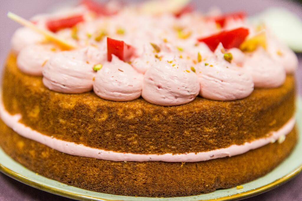 Een taart met roze creme en fruit