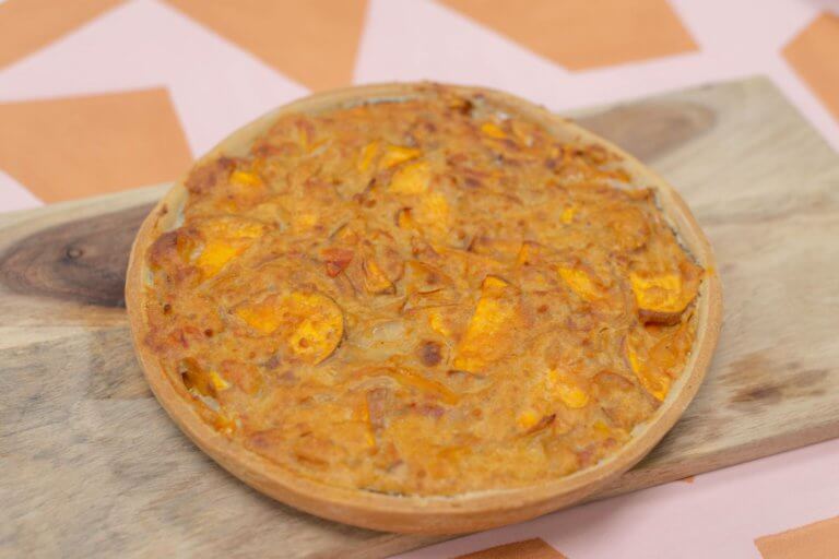 Een vegan quiche van Trashure Taarten, de bakker in Nijmegen, geserveerd op een serveerplank.