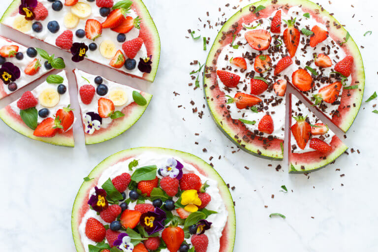 Rijkelijk versierde taarten met fruit.