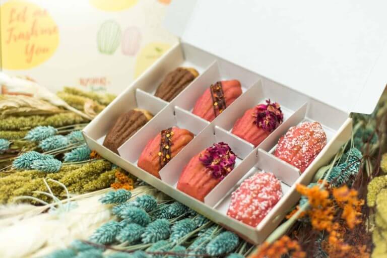 Acht madeleines in een mooie verpakking op een sfeervol versierde tafel.