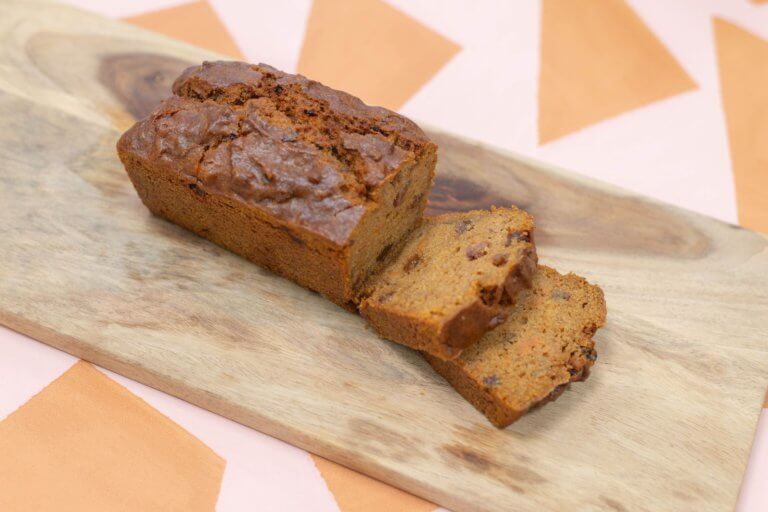 Een vegan zoete aardappel cake, geserveerd op een plank en in stukjes gesneden in onze bakkerij in Nijmegen.