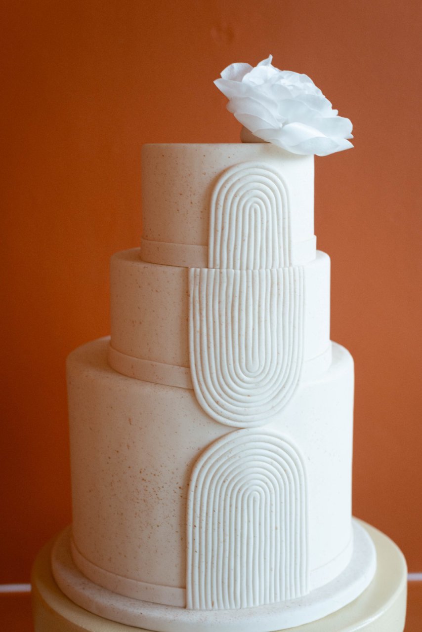 Een witte naked bruiloftstaart met strakke lijnen.